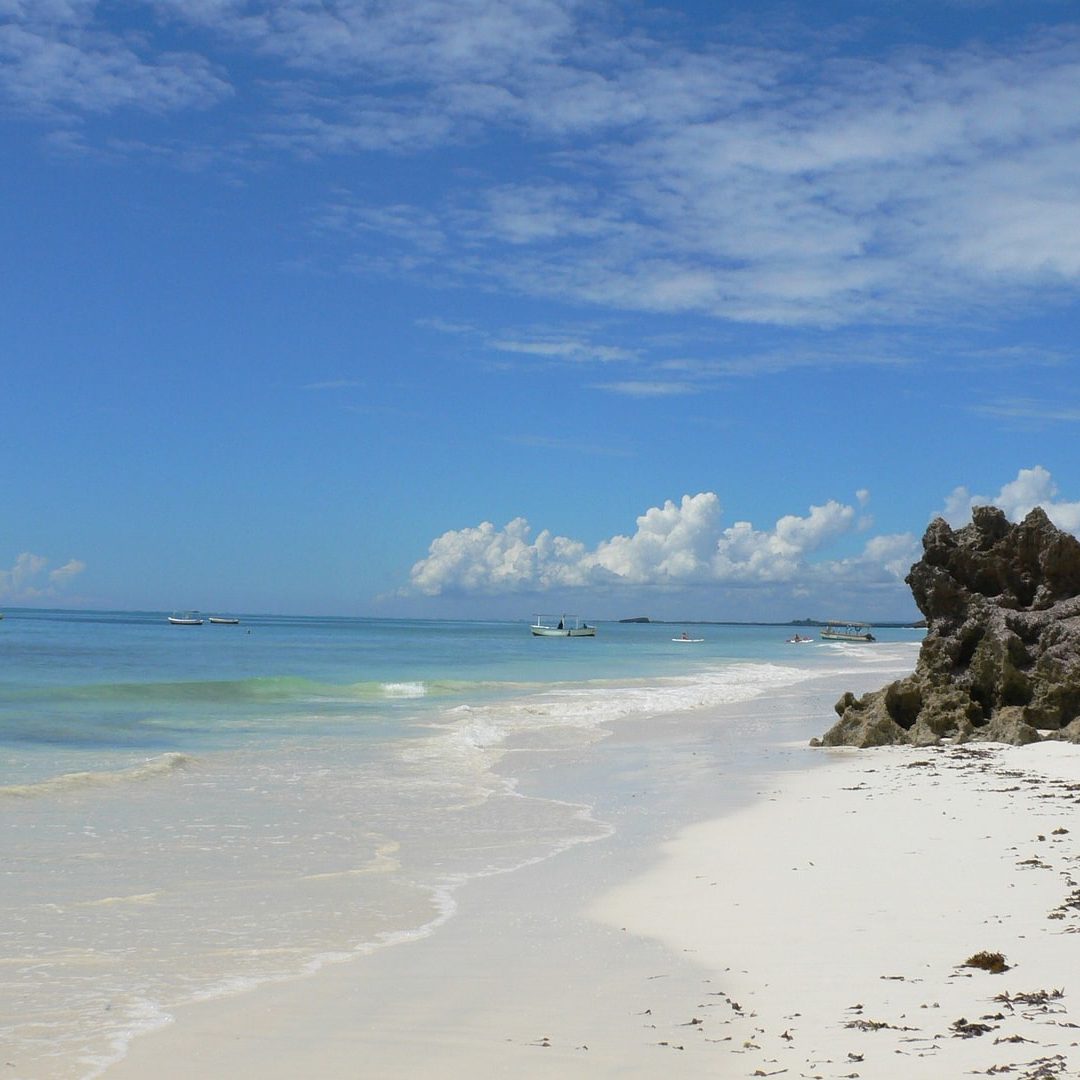 Here are alt texts for each image: 1. (top left) White sandy beach "White sandy beach with a small rocky islet and turquoise shallow waters at low tide